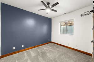 Unfurnished room featuring carpet flooring and a ceiling fan