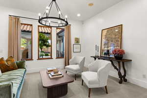 Living area featuring hanging lights and carpet