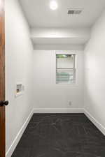 Laundry room with hookup for a washing machine and dark marble finish flooring