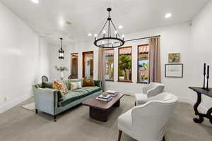 Living area with suspended lighting and carpet floors