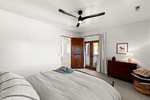 Carpeted bedroom featuring a ceiling fan