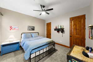 Carpeted bedroom featuring baseboards and ceiling fan