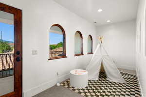 Recreation room with light colored carpet and recessed lighting
