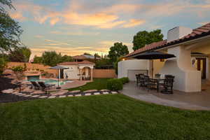 Fenced backyard with a patio, outdoor dining area, and an outbuilding