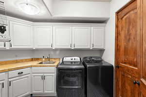 Laundry area featuring separate washer and dryer and cabinet space