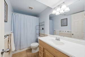 Bathroom with vanity, light tile patterned floors, and shower / bath combination with curtain
