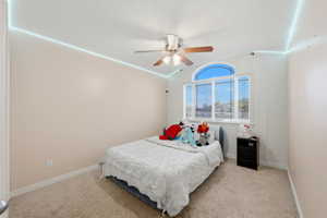 Bedroom with a ceiling fan and light colored carpet