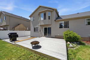 Back of house featuring a fire pit and a wooden deck