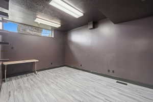 Spare room with a textured ceiling and light wood-style flooring