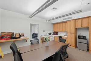 Dining room with light carpet and a desk