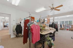 Miscellaneous room featuring a ceiling fan and a textured ceiling