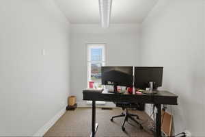 Office area featuring light colored carpet and baseboards