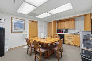 Dining space featuring a paneled ceiling and light colored carpet