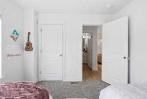Bedroom with light colored carpet and baseboards