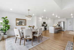 Dining area featuring light wood-style floors and hanging lights