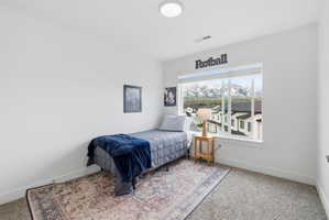 Bedroom with light colored carpet and baseboards