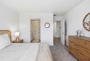 Bedroom with light carpet and ensuite bath