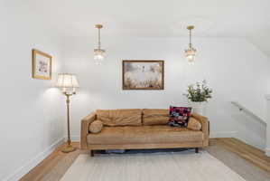 Sitting room featuring a chandelier, light wood-style flooring, and an upstairs landing