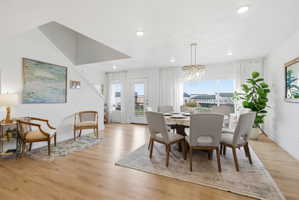 Dining room with light wood-style flooring and hanging lights