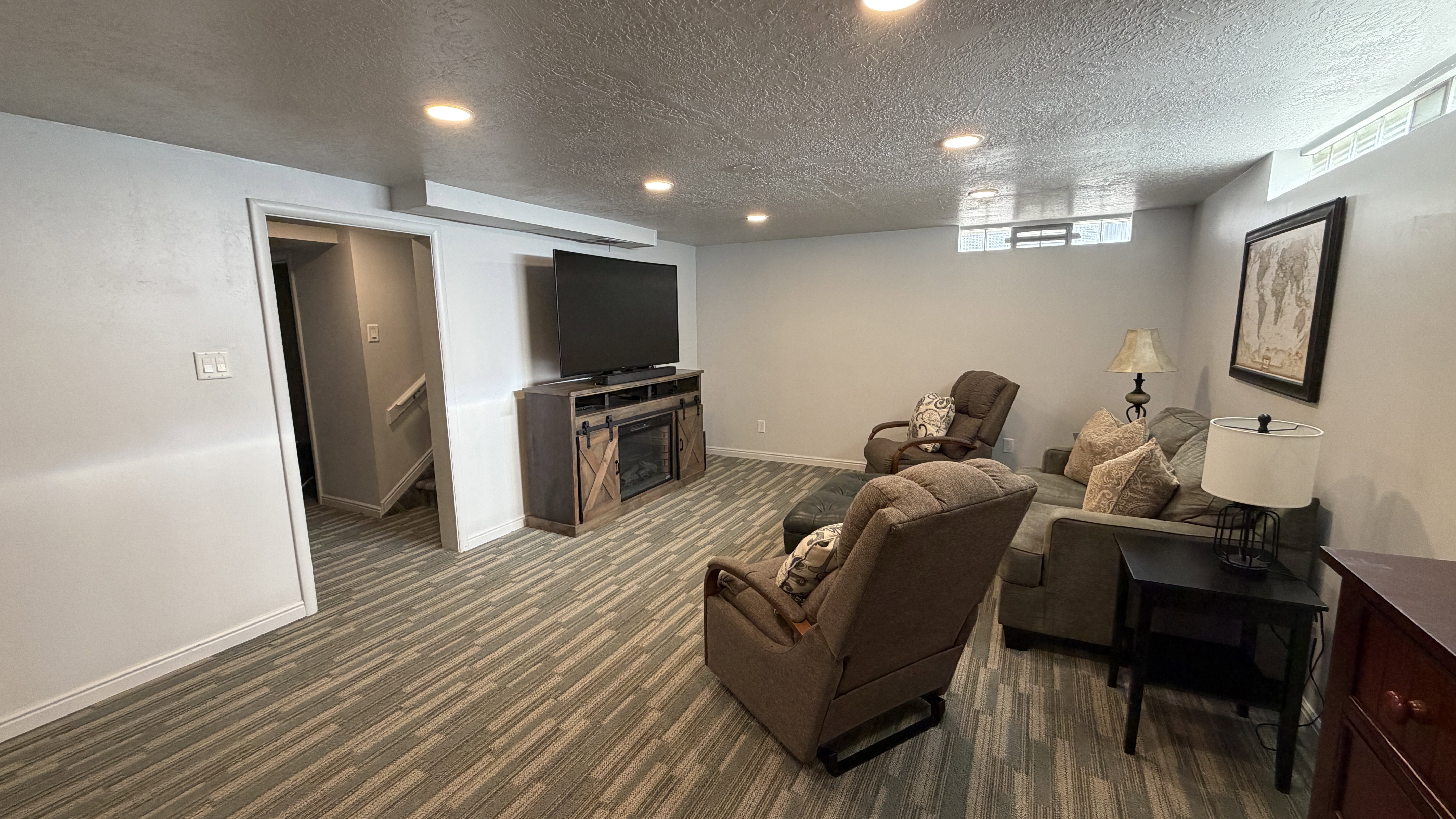 Living room featuring recessed lighting, a textured ceiling, dark carpet, and a fireplace