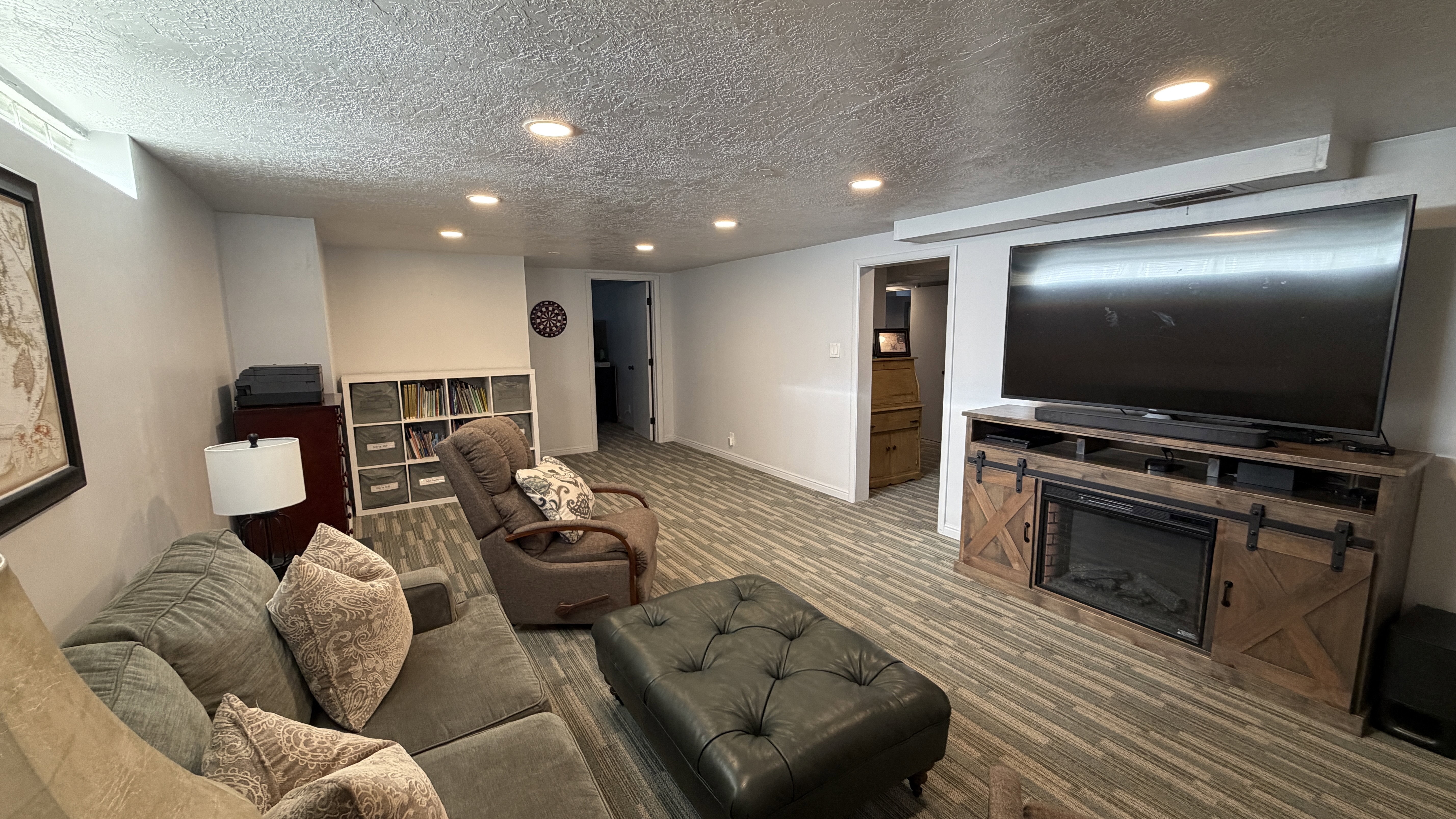 Living room featuring a textured ceiling, recessed lighting, and carpet