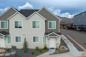 View of front of house featuring board and batten siding, a shingled roof, and a mountain view