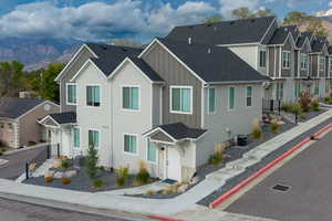 Traditional home featuring board and batten siding, roof with shingles, a residential view, and a mountain view