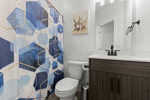 Bathroom featuring a shower with shower curtain and vanity