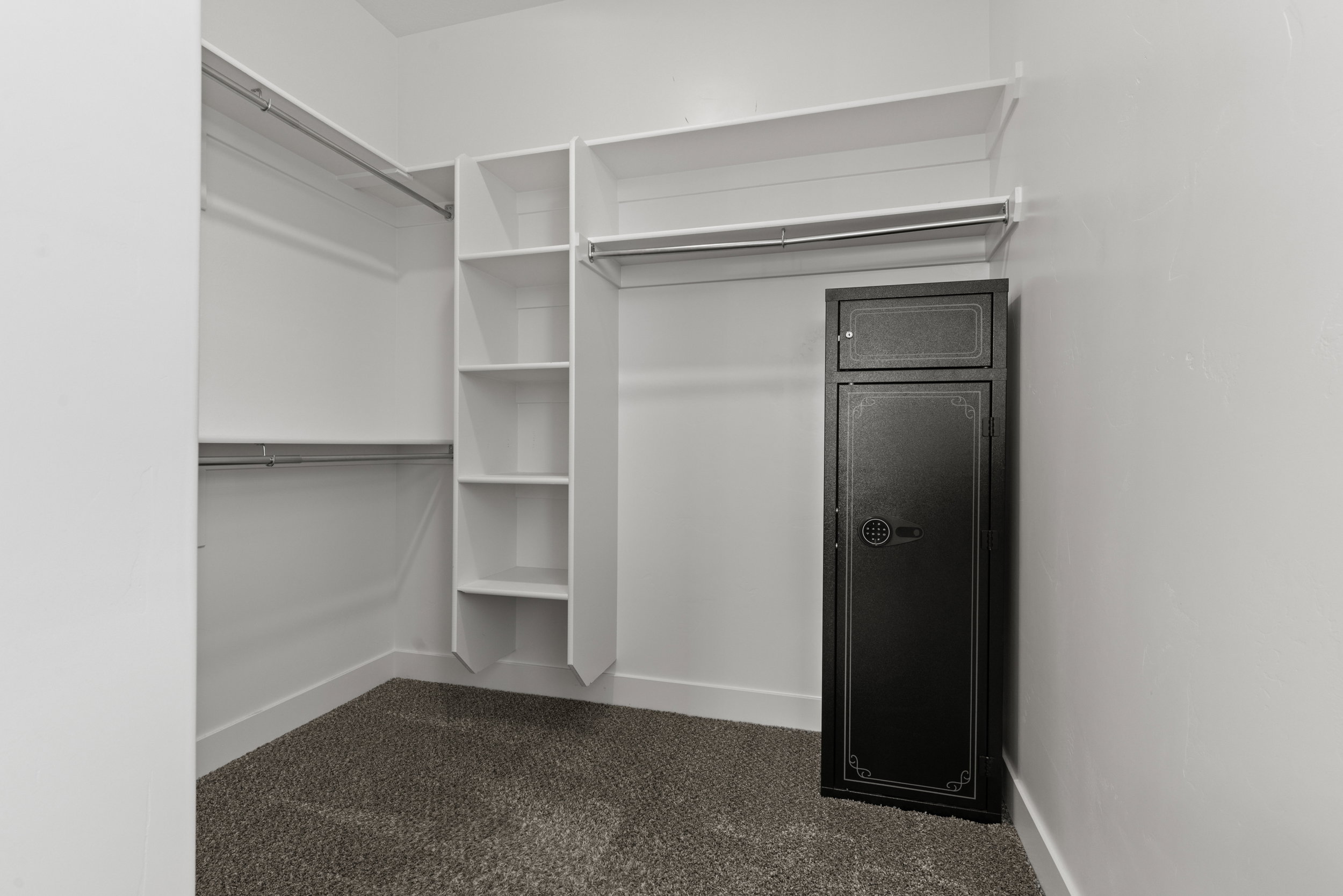 Walk in closet with dark colored carpet