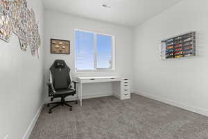 Office with light colored carpet and baseboards