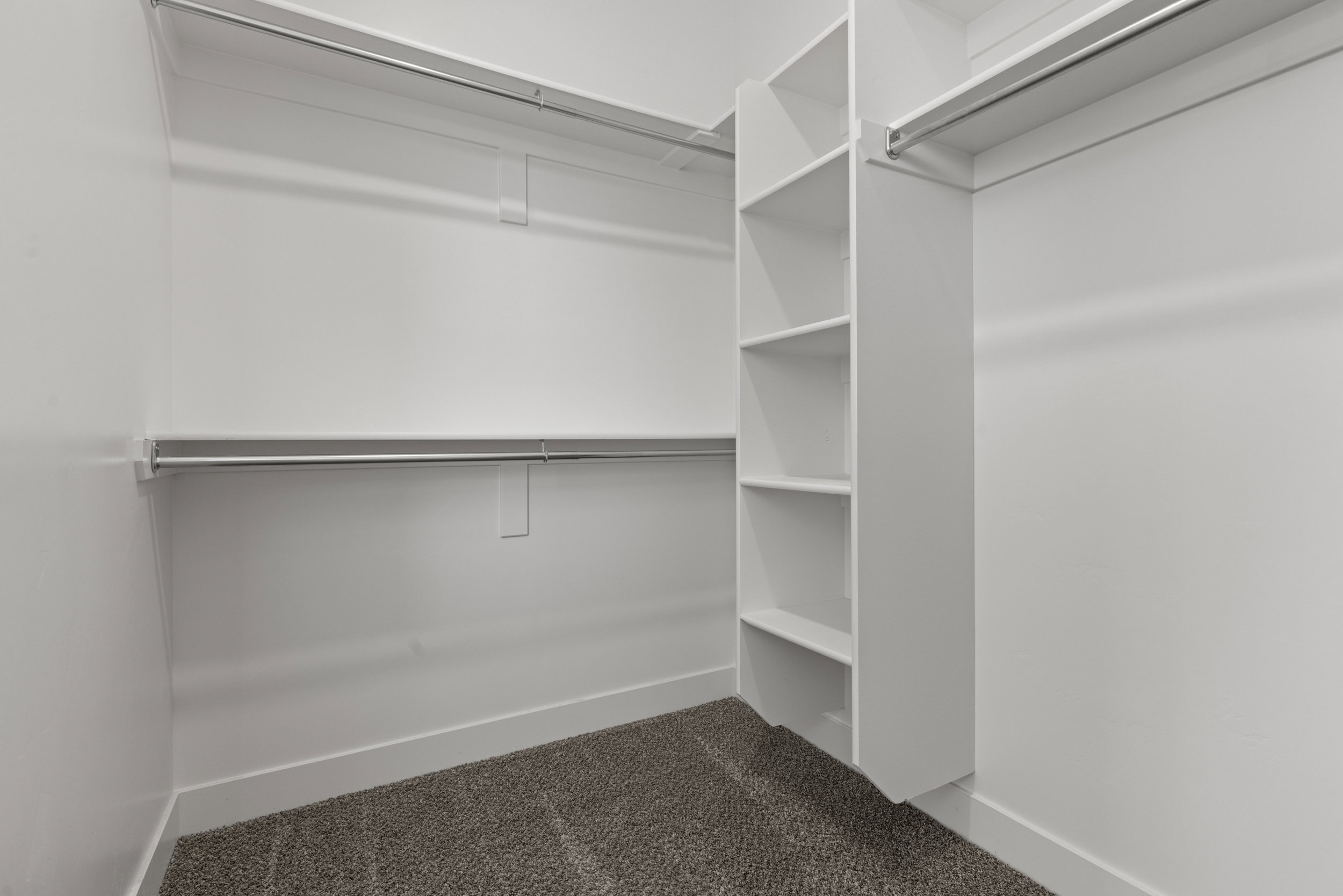 Walk in closet featuring dark carpet