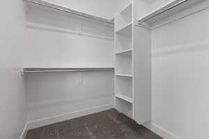 Walk in closet featuring dark carpet