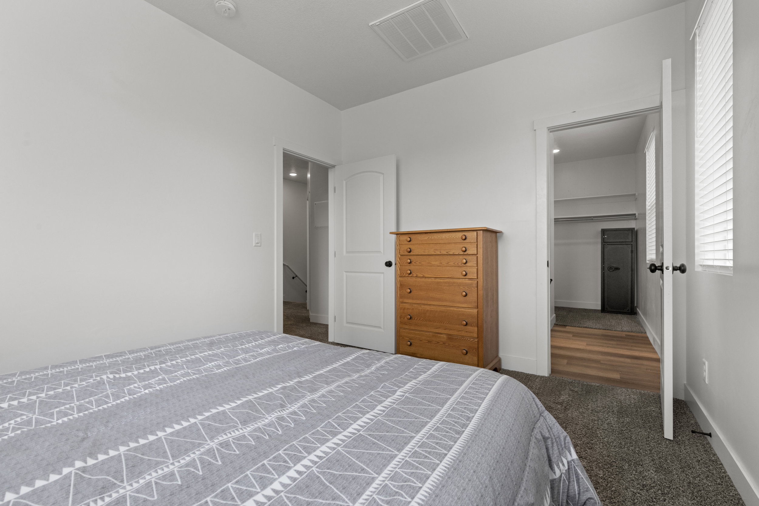 Bedroom with a walk in closet and dark carpet
