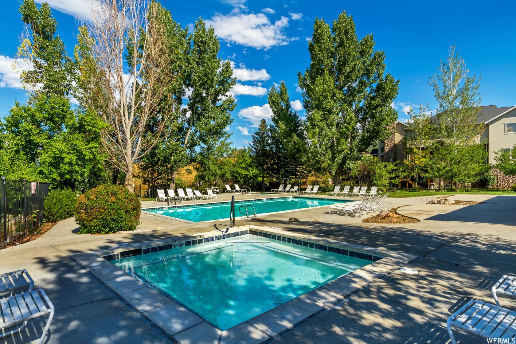 Community pool featuring a patio and a hot tub