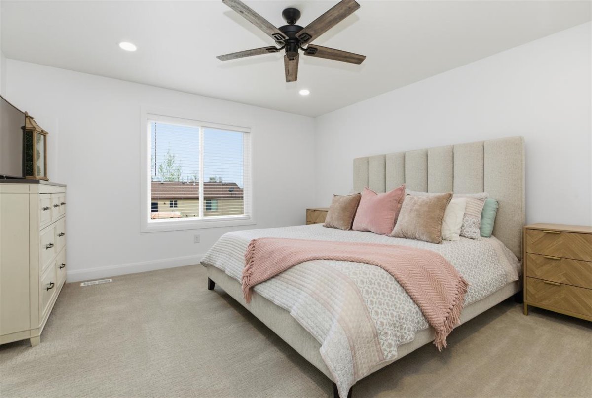 Bedroom with light carpet, ceiling fan, and recessed lighting