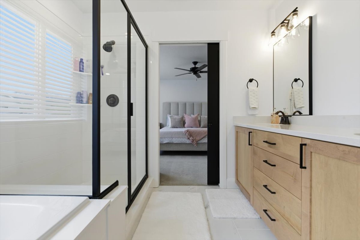 Bathroom with ensuite bath, double vanity, a shower stall, a bath, and ceiling fan