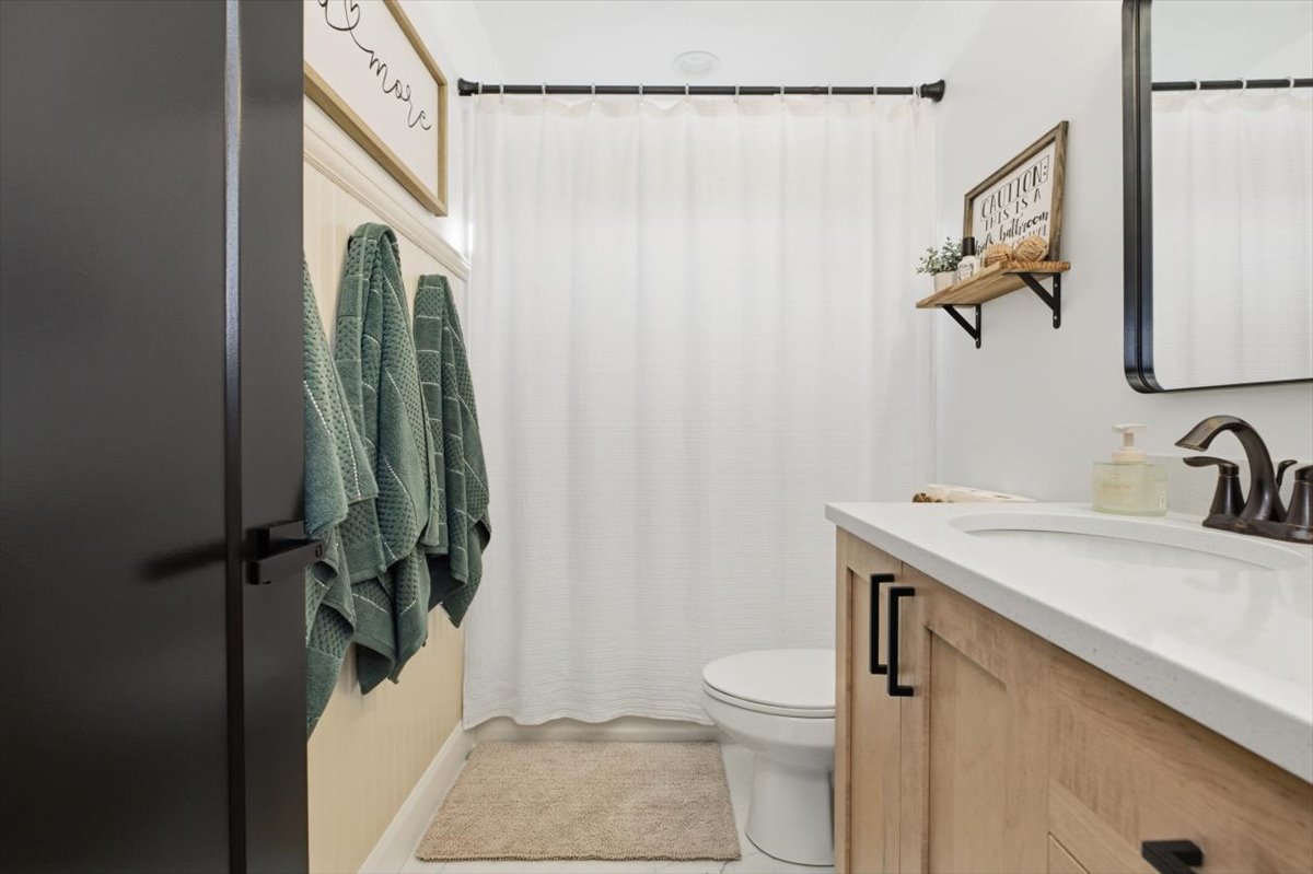 Full bath featuring a shower with shower curtain and vanity