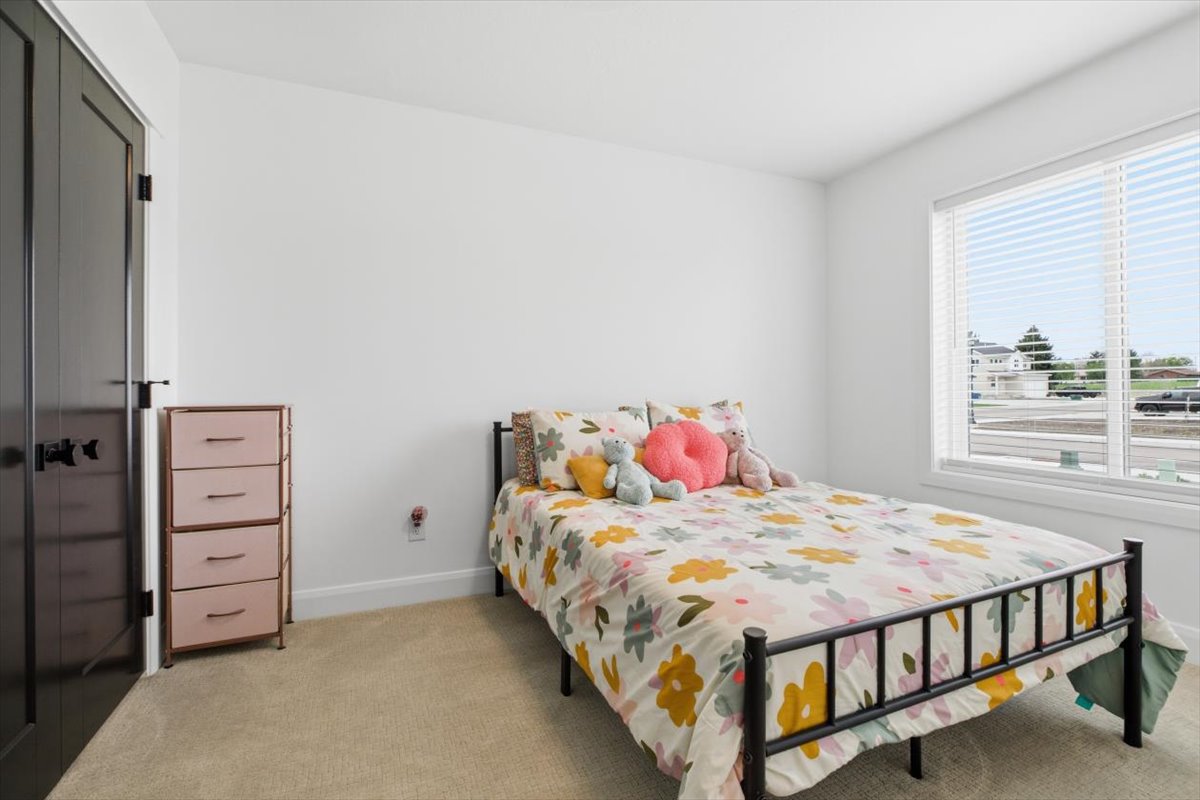 Bedroom with light colored carpet and a closet