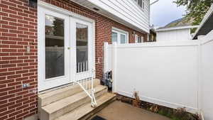 Property entrance featuring brick siding and french doors