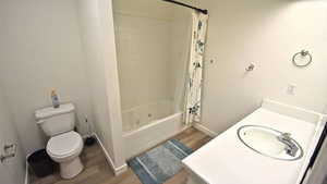 Full bathroom featuring vanity, shower / tub combo, and dark wood finished floors