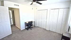 Home office with carpet flooring and ceiling fan