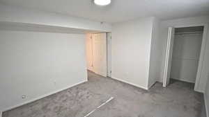 Unfurnished bedroom with carpet, a closet, and a textured ceiling
