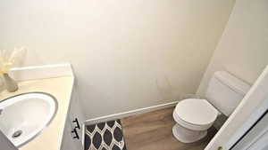 Half bath featuring wood finished floors and vanity