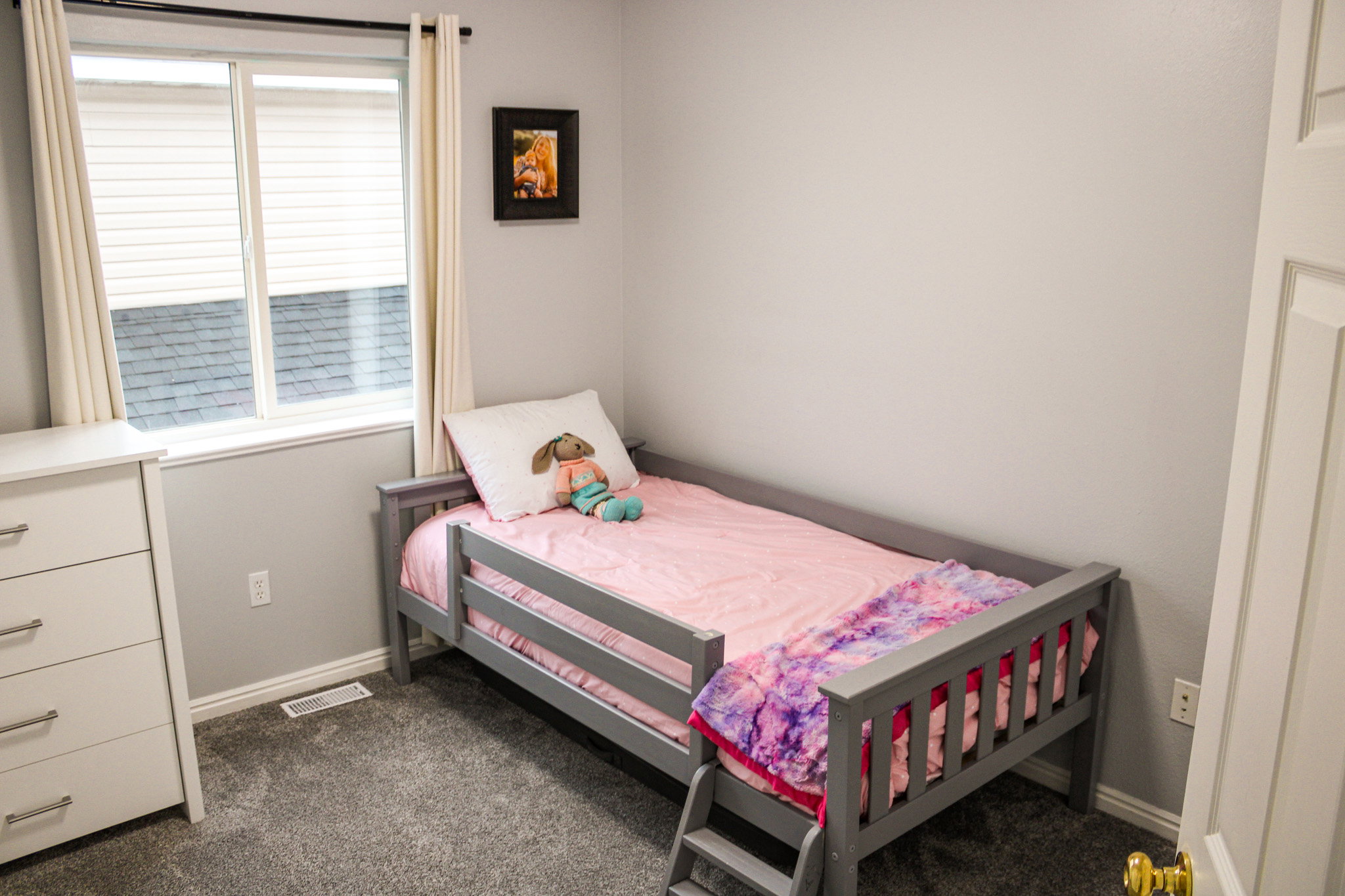 Bedroom with dark carpet and baseboards