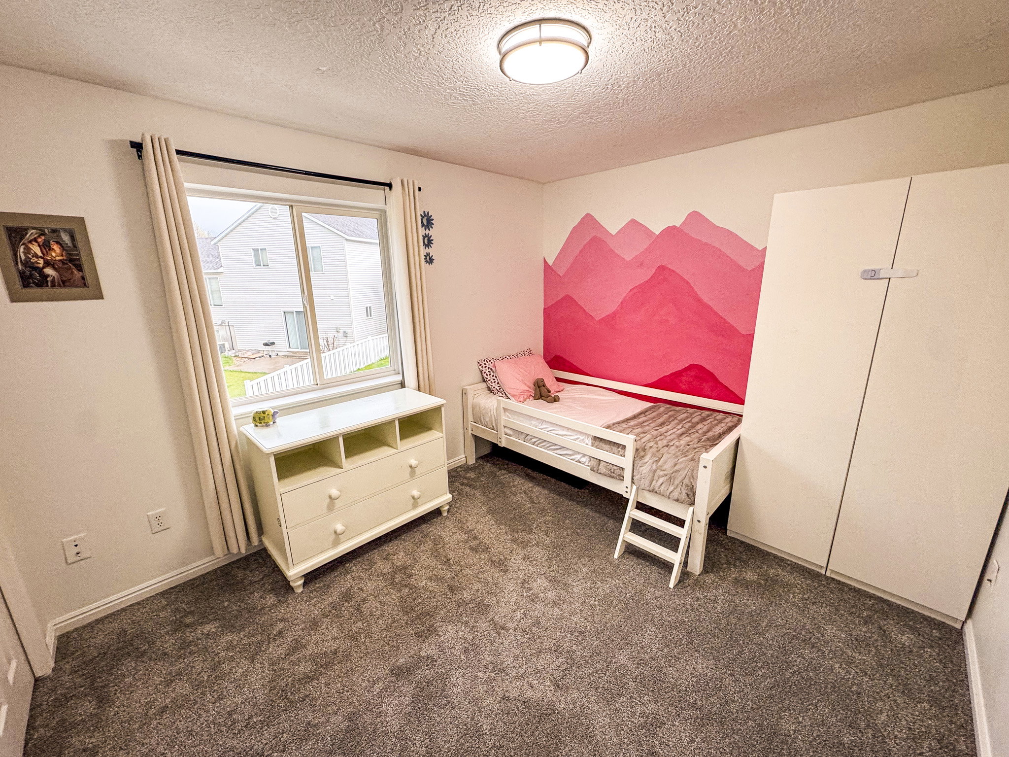 Bedroom with dark carpet and a textured ceiling
