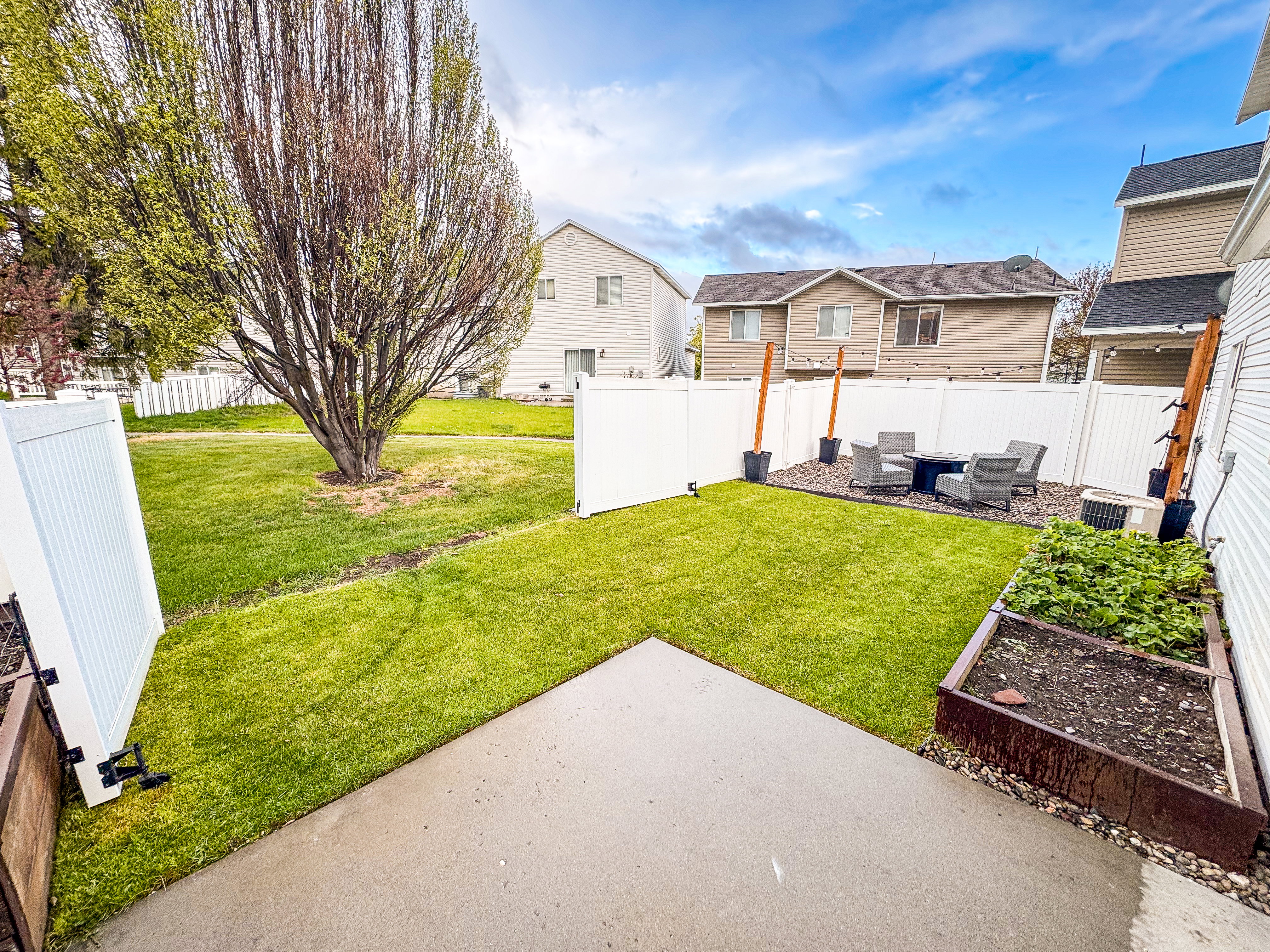 Fenced backyard with a garden, a residential view, and a patio