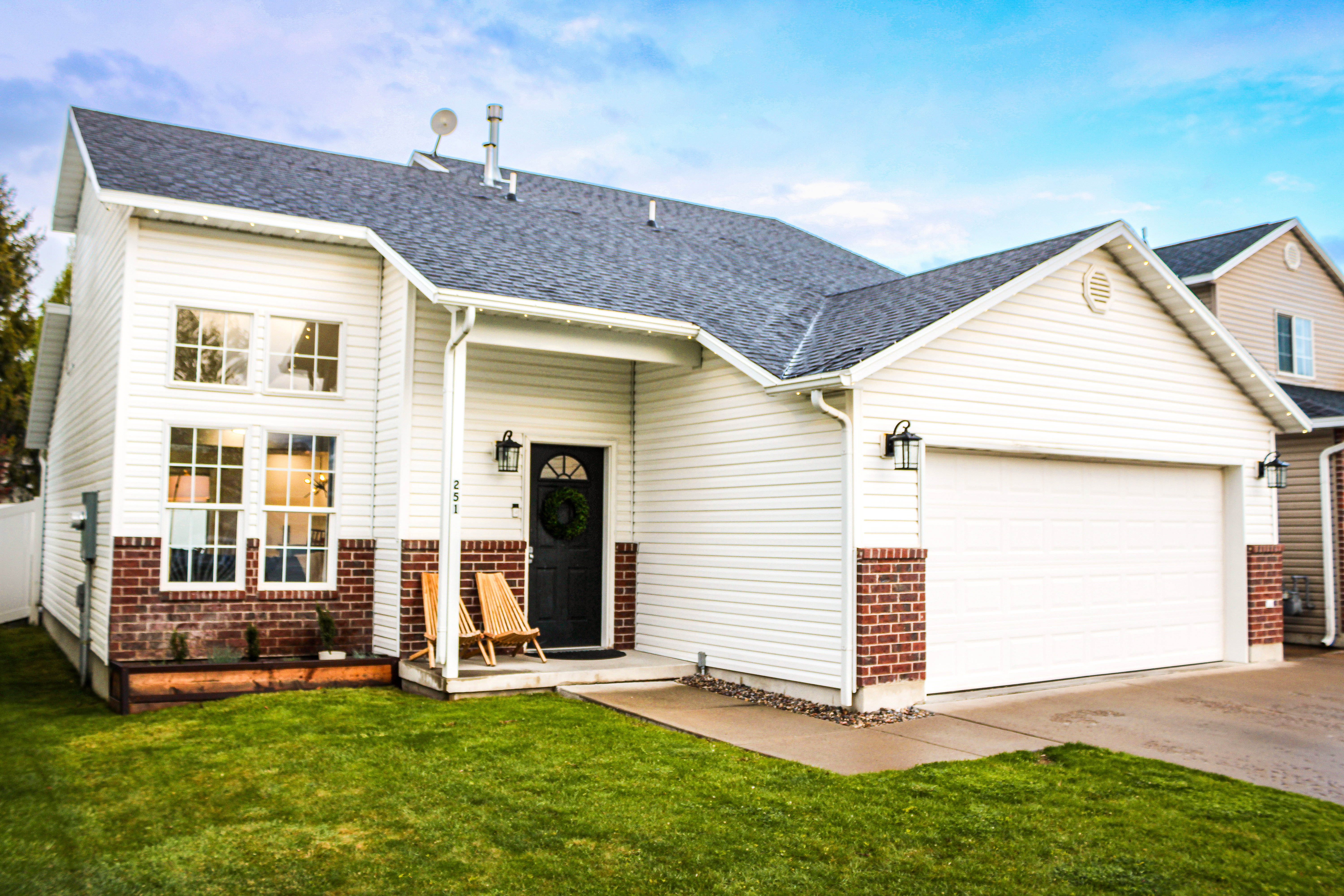 View of front of property featuring an attached garage, roof with shingles, driveway, and brick siding