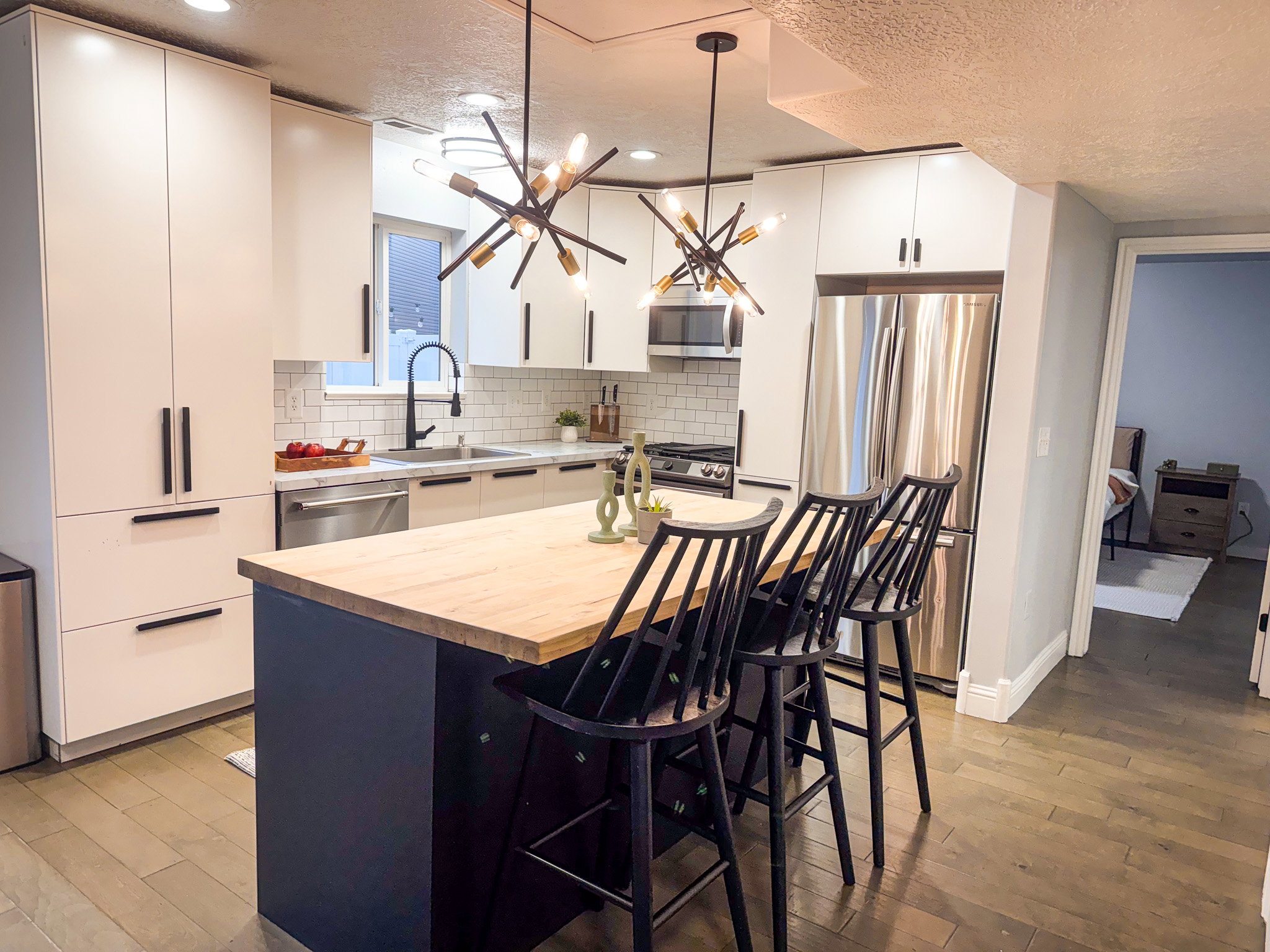 Kitchen featuring wooden counters, a kitchen breakfast bar, decorative light fixtures, stainless steel appliances, and a textured ceiling