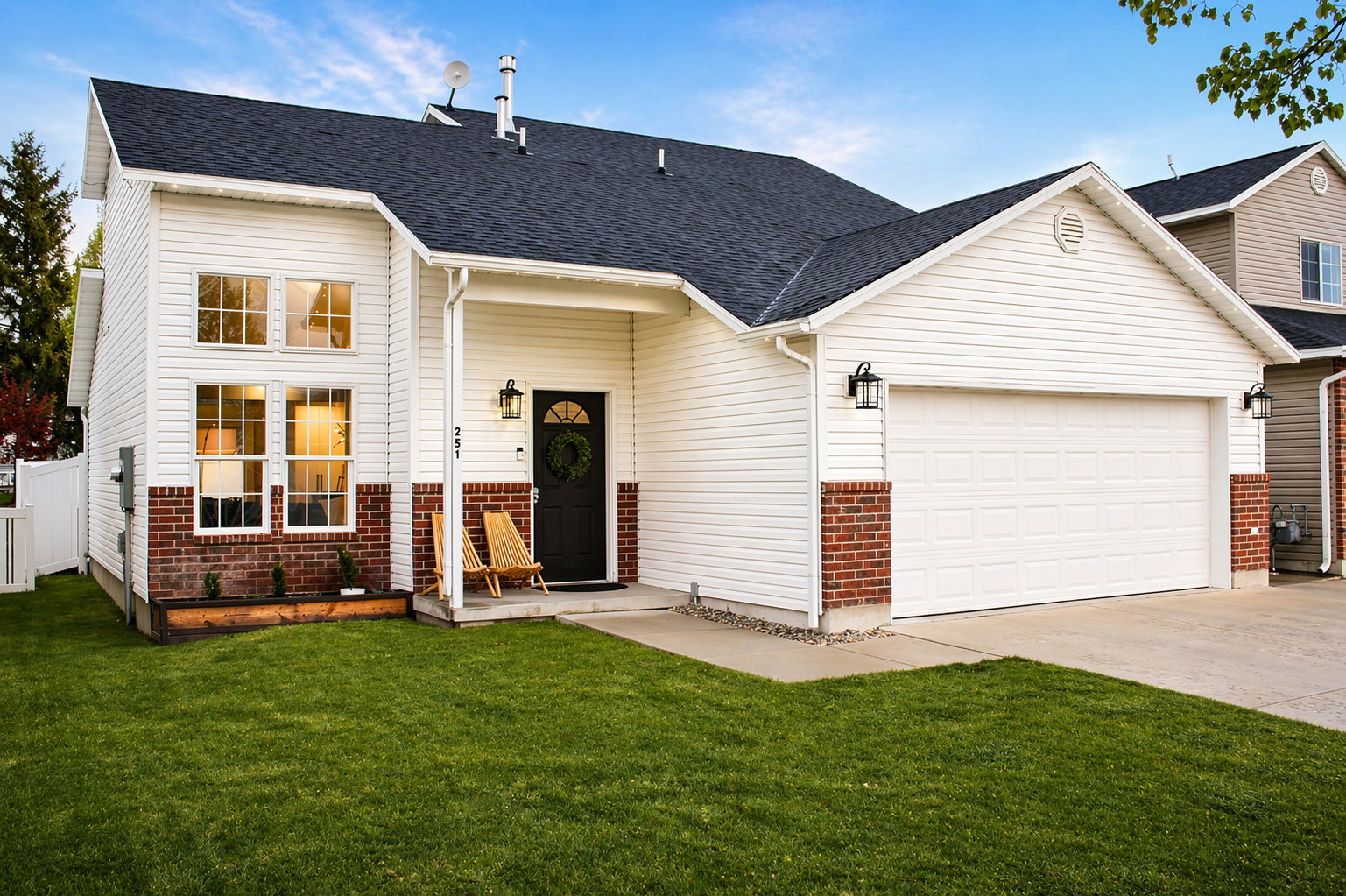 View of front of house featuring an attached garage, driveway, a shingled roof, and brick siding