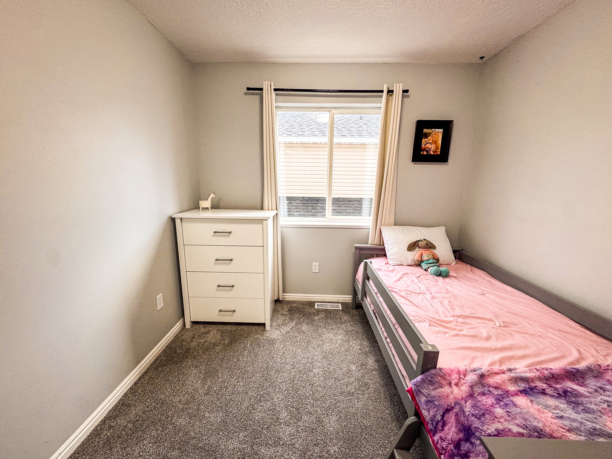 Bedroom featuring dark colored carpet and a textured ceiling